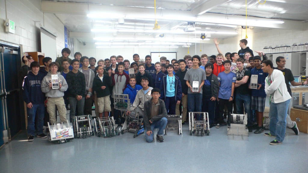 The VEX program gathered in the Bellarmine lab behind seven robots