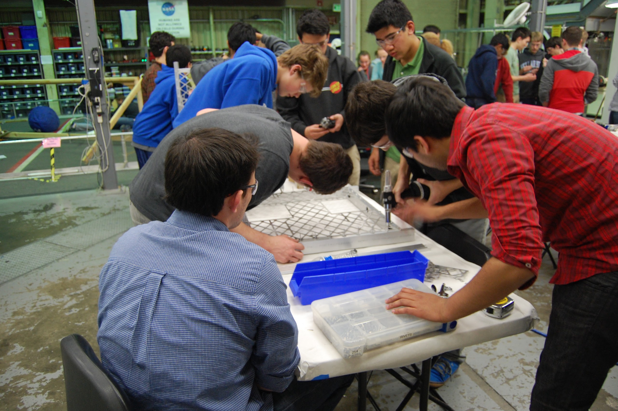 Base plate being riveted together. Once all pieces were attached it was cleaned with wire brushes for welding.