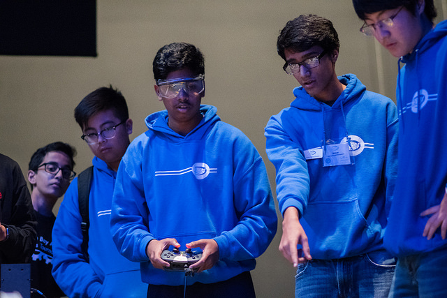 Students on Team 254H driving their robot during a match.